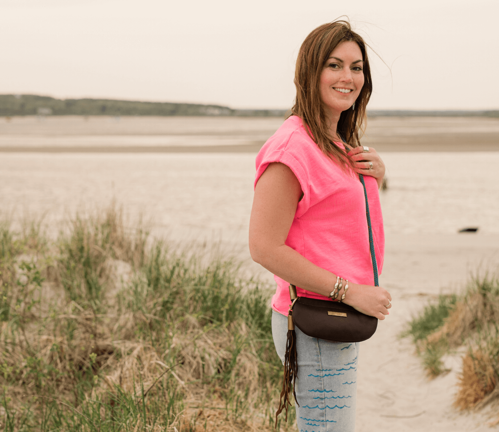 woman wearing a pink shirt and a brown leather bag