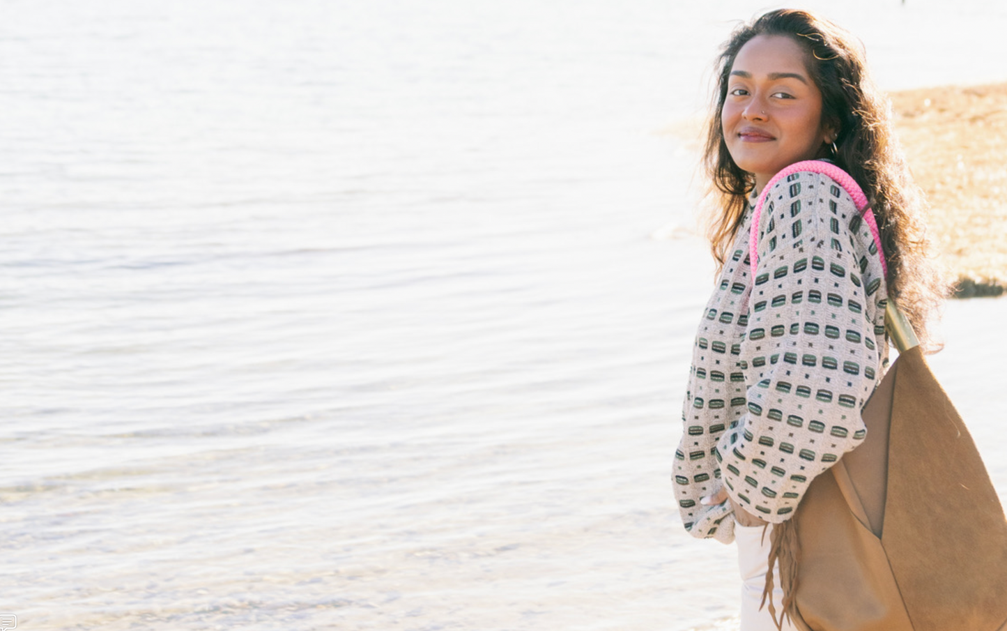 woman on the beach wearing a Wildwood bag with pink beach rose rope