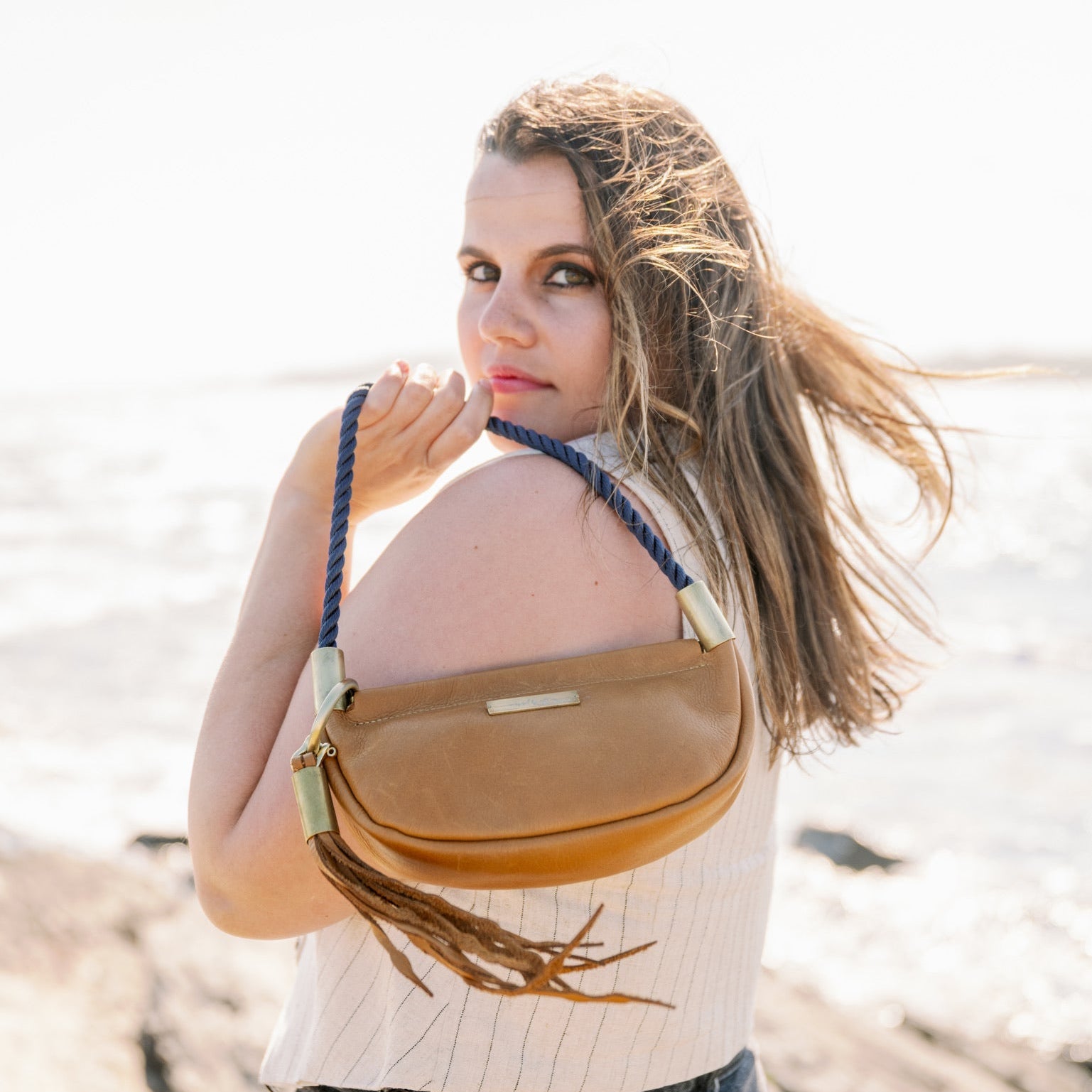 Woman with a tan leather bag on a beach