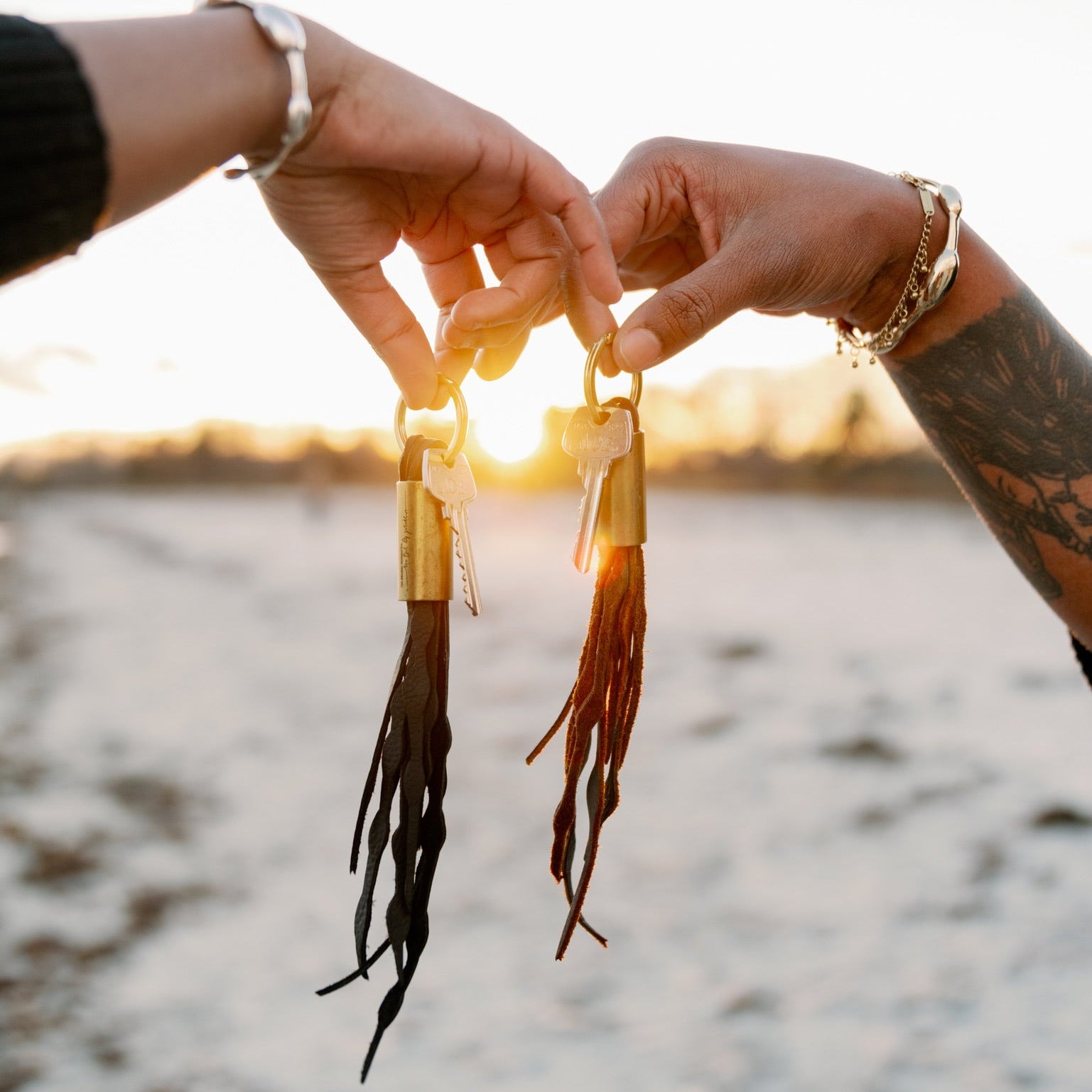 Two hands holding dried seaweed against a sunset over water background