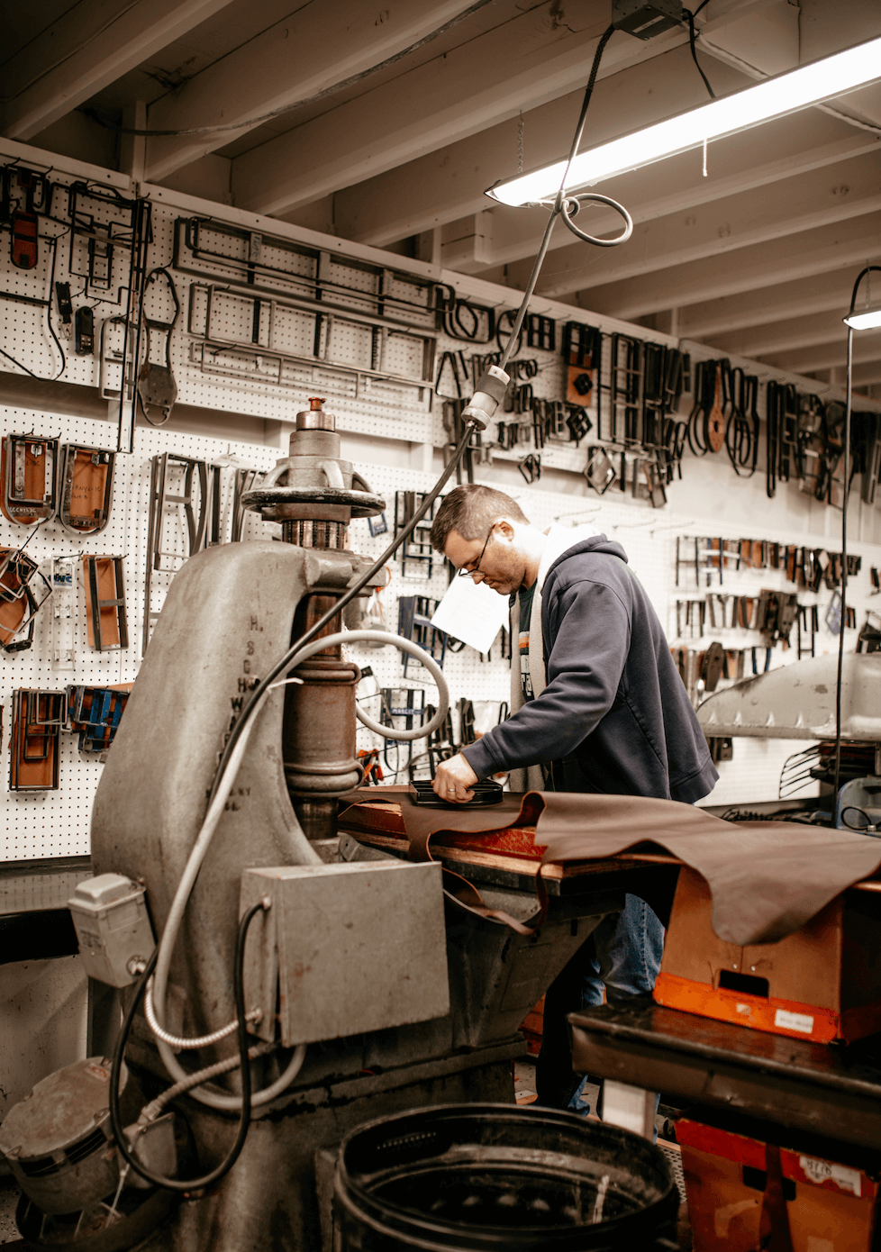 man cutting leather on a press