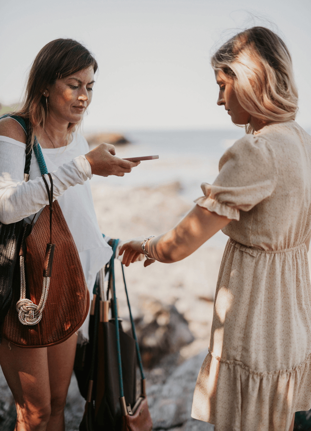 woman taking picture of another woman's hand