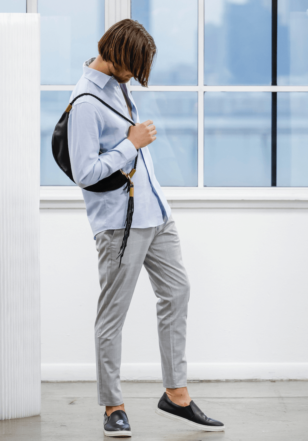 man wearing a black leather sling bag
