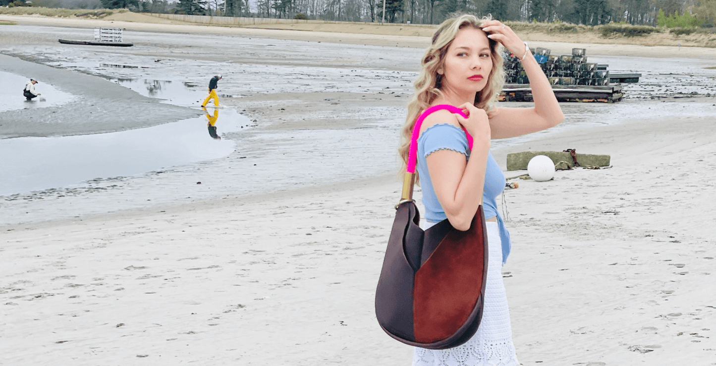 woman on the beach with a brown leather tote with neon pink dock line