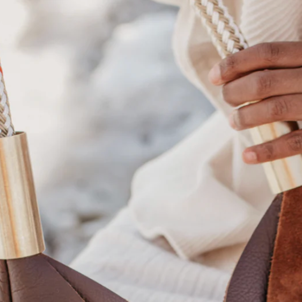 Close-up of a hand holding a woven bag with a blurred background