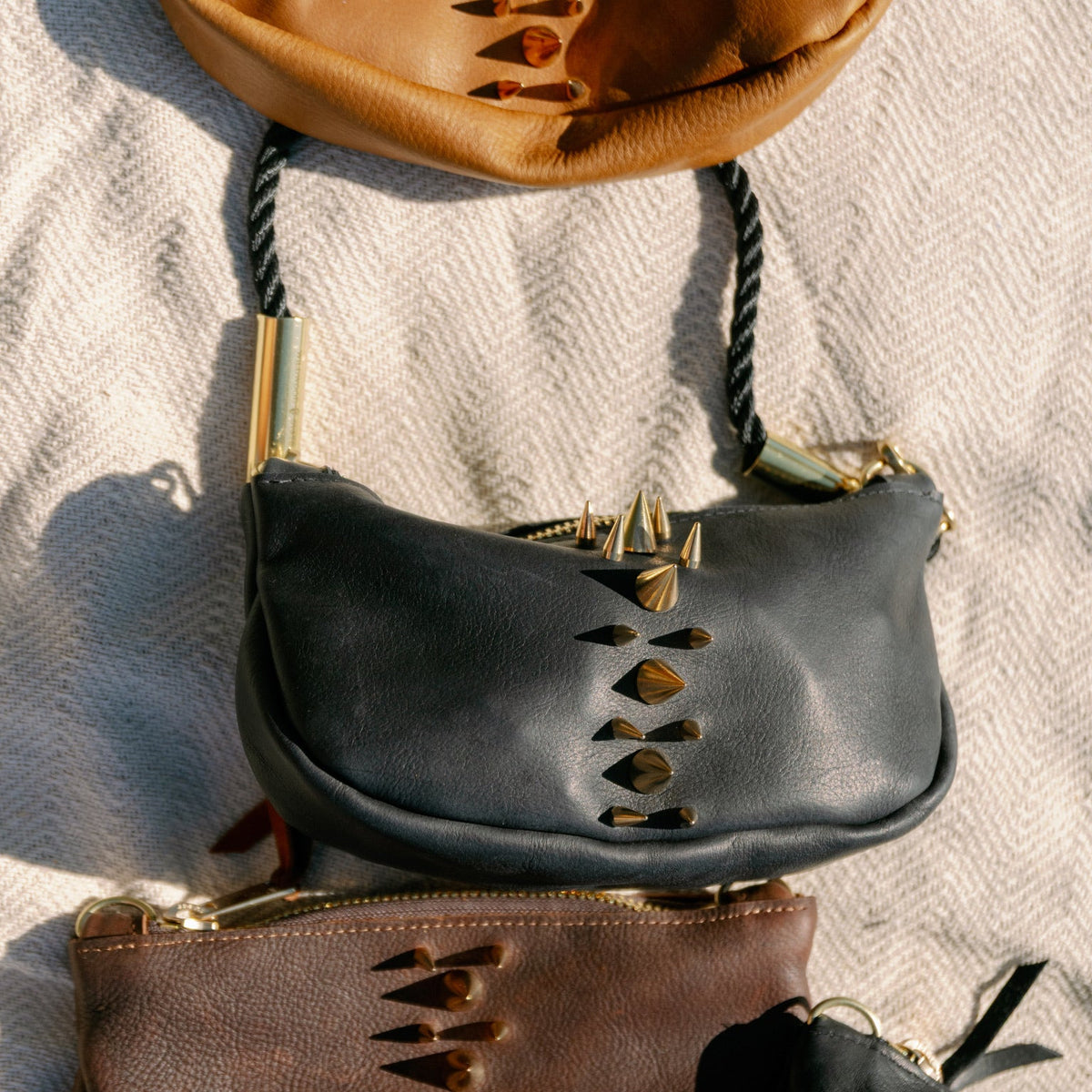 An upclose shot of the Black Sea Urchin Convertible bag on a blanket