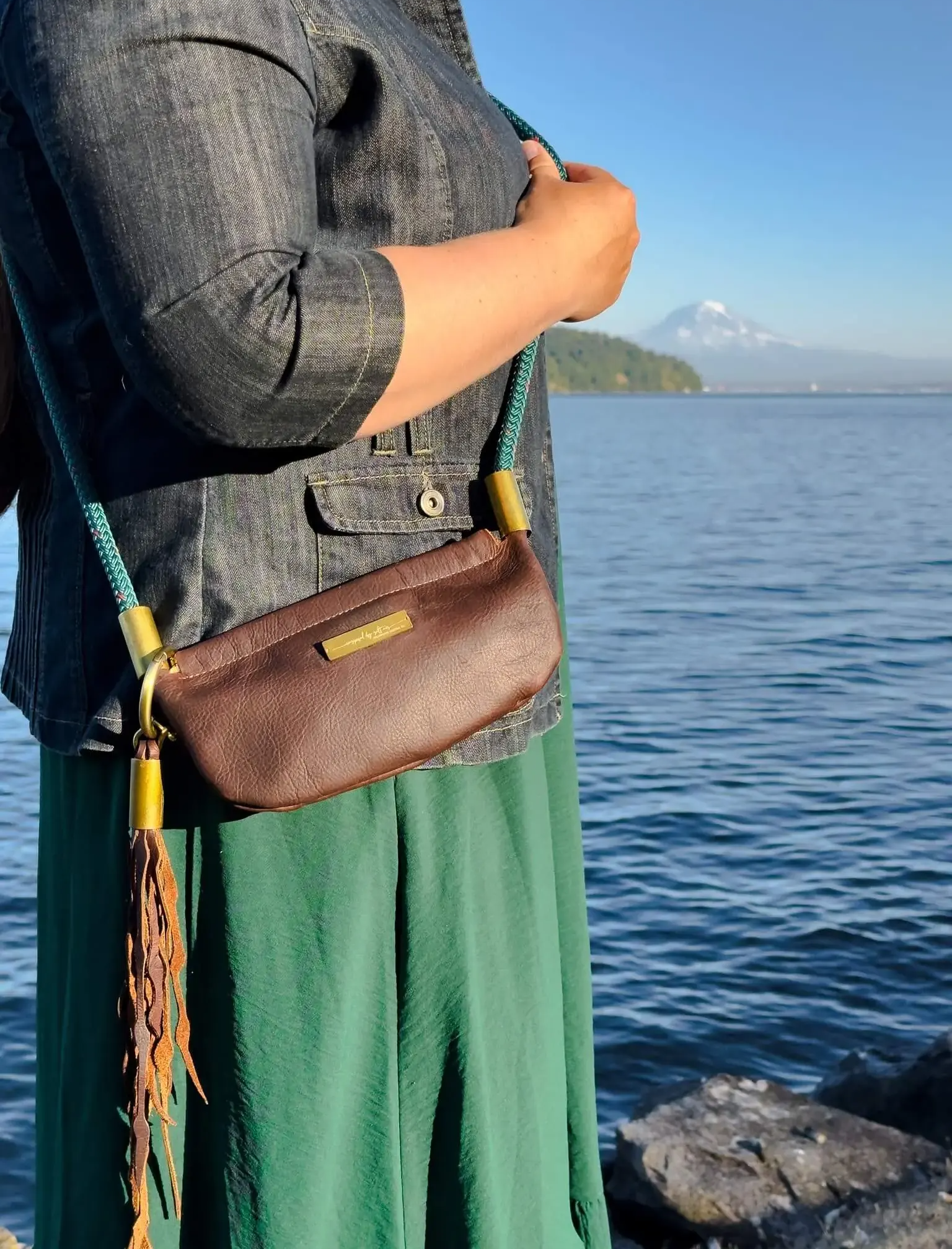 brown leather bag worn as a crossbody with a leather seaweed tassel