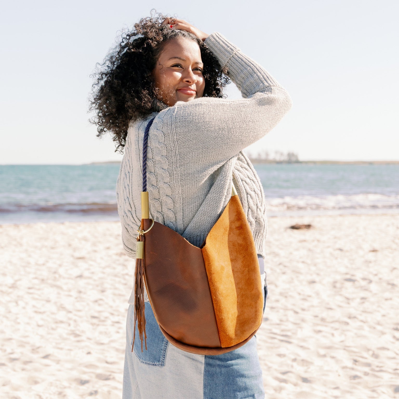 Woman with a brown leather handbag on a beach