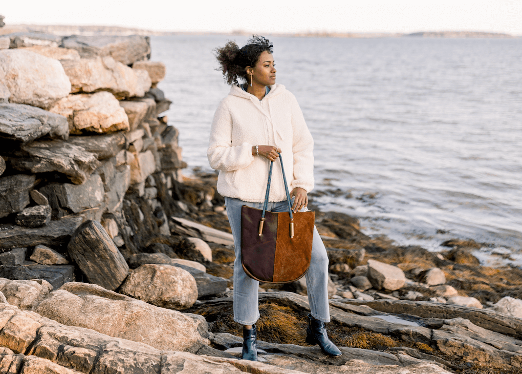 Woman holding brown leather zip tote