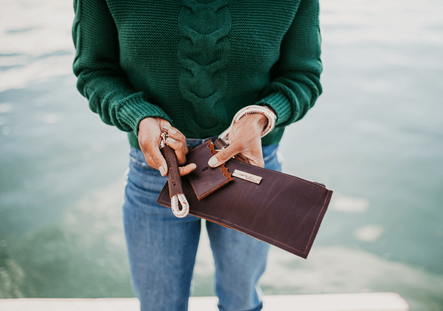 Woman holding keychain, wallet, and clutch