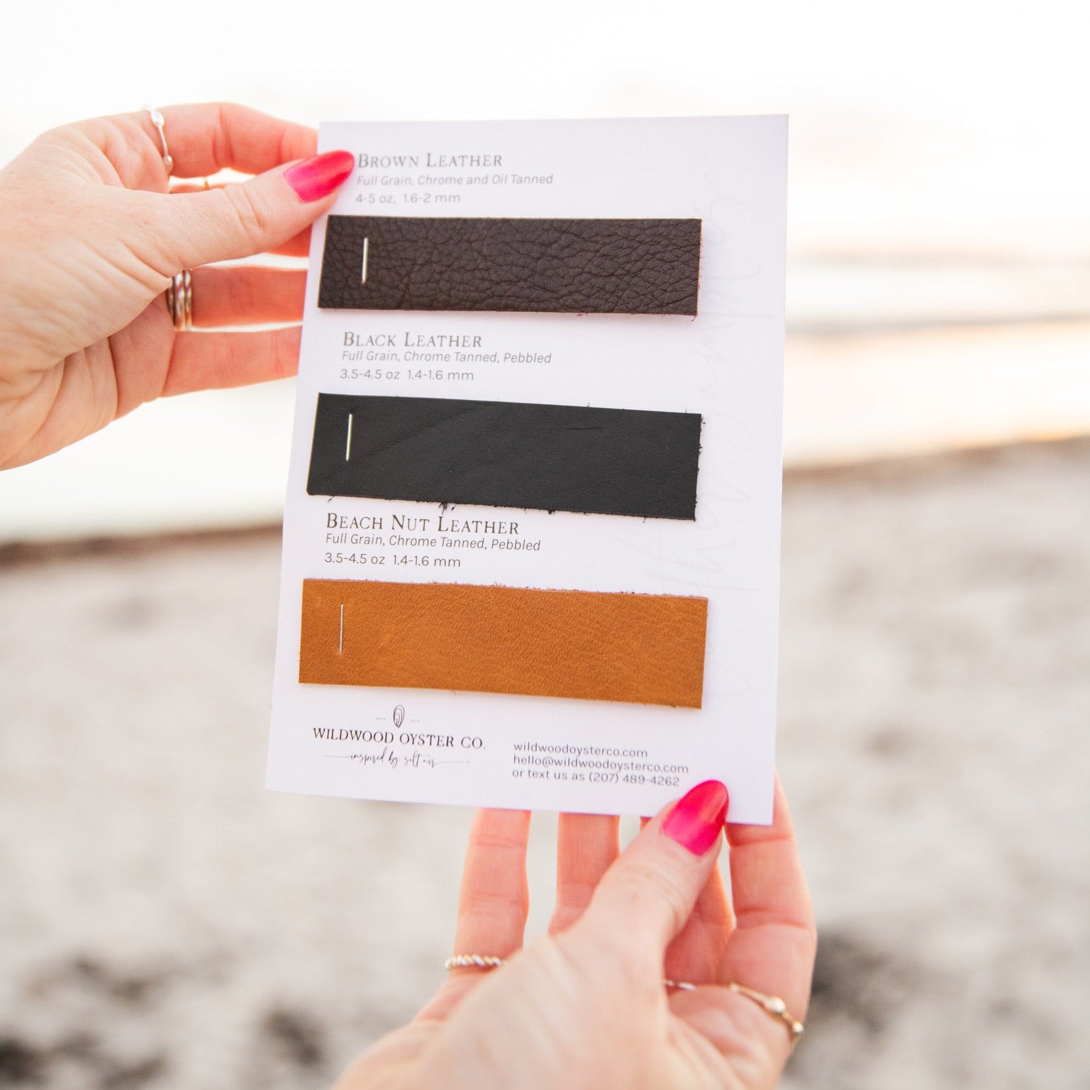 Two hands holding up a leather swatch card with brown leather, black leather, and beach nut leather