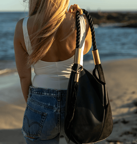 woman wearing a black leather bag and white tank top