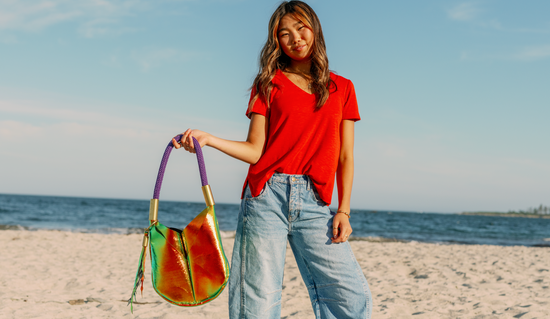 Woman holding a colorful handbag on a beach