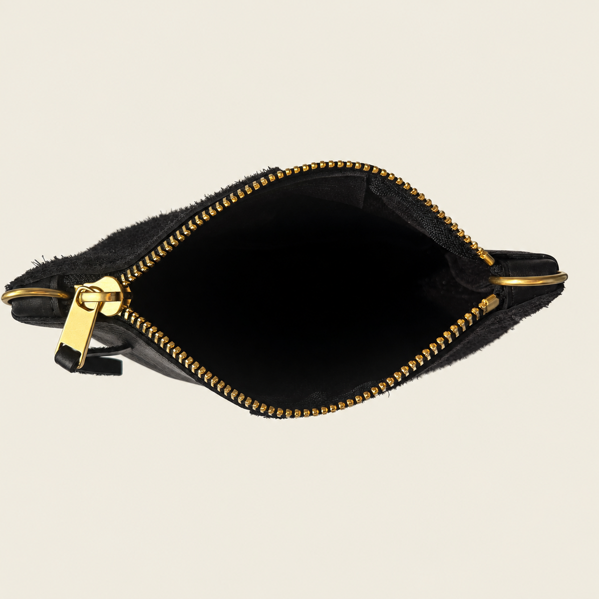 A black faux fur zip pouch with gold-tone hardware, shown open against a light beige background.