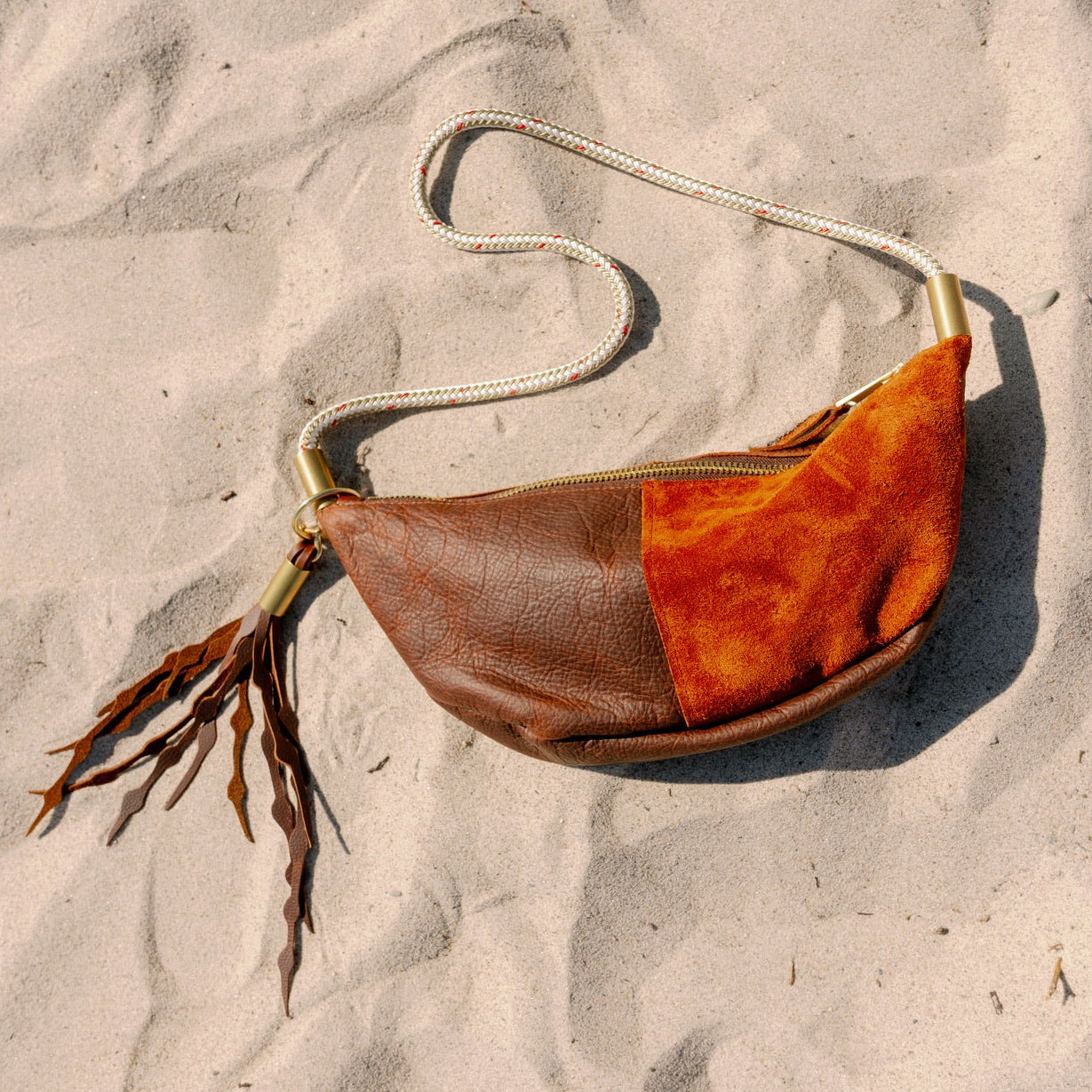 Brown leather bag on sandy beach